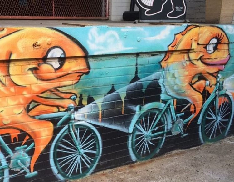 A mural of two goldfish riding bicycles, painted on a wall in Philadelphia’s Fishtown, reflects the neighborhood’s funky feel.