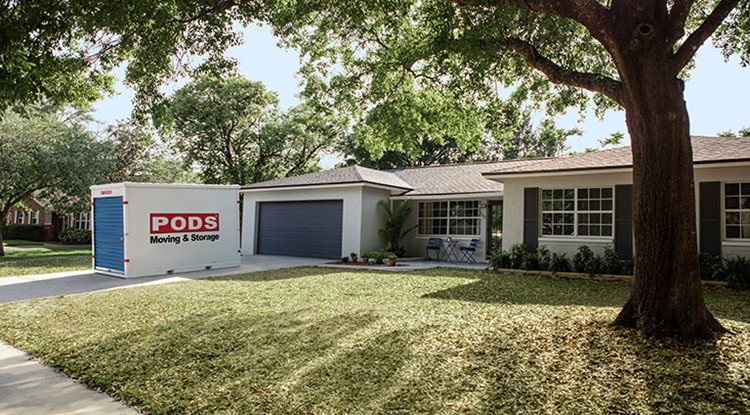 A PODS moving and storage container sits in the driveway of a newly purchased home.