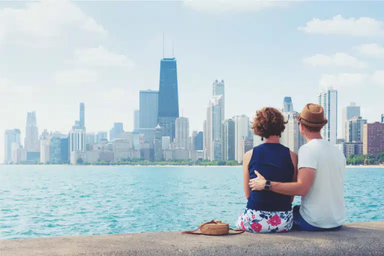 A couple is sitting together while looking out over the water at the Chicago skyline on a nice summer day.