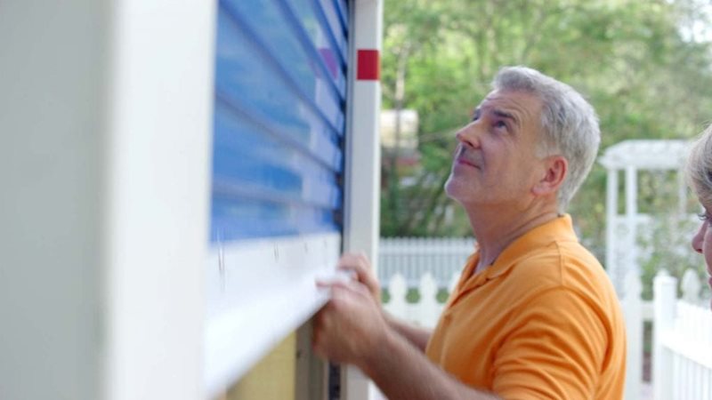 A man in an orange shirt closes his PODS storage container