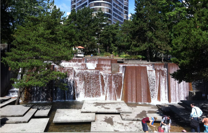 Locals in Portland, Oregon, cool off at the Keller Fountain in Keller Fountain Park on a sunny summer day.