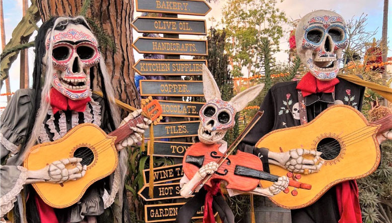 Life-size decorations for Dia de los Muertos in San Diego. There's a man and woman painted skeleton, holding acoustic guitars, and a rabbit skeleton, holding a violin.