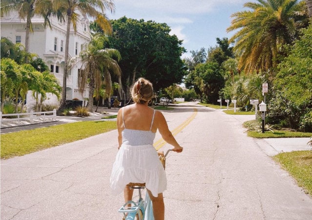 A local woman rides her bike through a neighborhood in Sarasota, Florida.