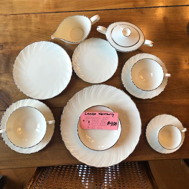 A white, antique dish set with a pink price tag that doesn’t just say what they are and how much they are; it includes details about the set, so the buyer can feel comfortable about paying the $400 written on the tag.