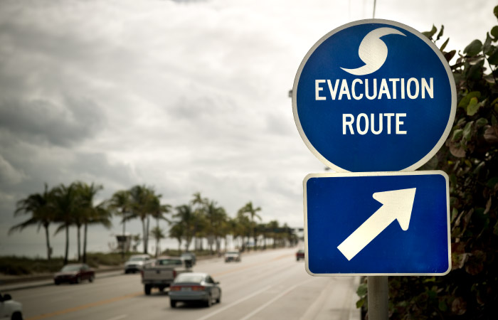 Cars travel along a freeway in Florida past a hurricane evacuation route sign.