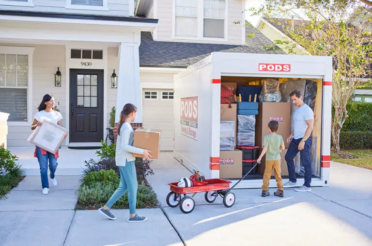 family loading PODS container in driveway