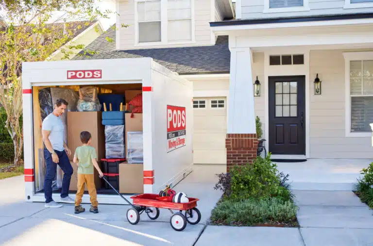 A family loading up their PODS container in their driveway