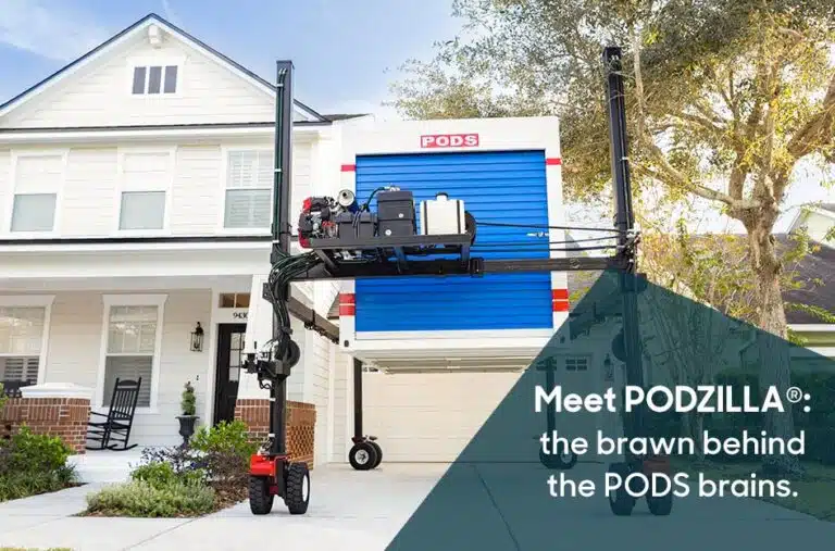 PODZILLA being used to position a PODS portable moving container in a customer’s driveway. There’s a translucent blue shape over the bottom right corner of the image with white lettering that reads “Meet PODZILLA®: the brawn behind the PODS brains.”