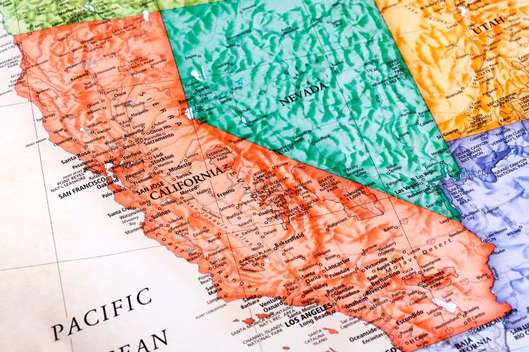 Close-up view of a map of the Pacific Coast of the United States, showing all of California and most of Nevada, as well as little bits of other surrounding states. Each state is colored uniquely. 