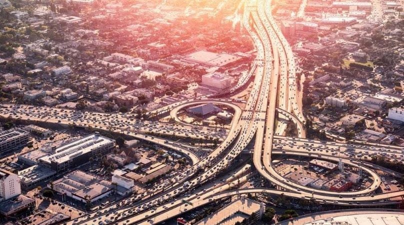 Aerial view of a crowded collection of freeways in California with ramps circling over and under roadways