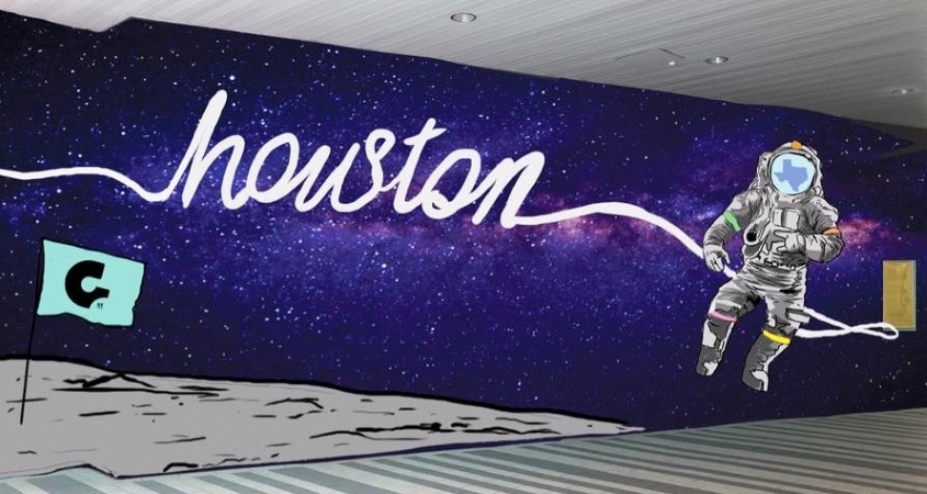 A space-themed mural in Houston, Texas, featuring a moonscape with an astronaut floating among the stars. The astronaut’s tether spells out “Houston.” 