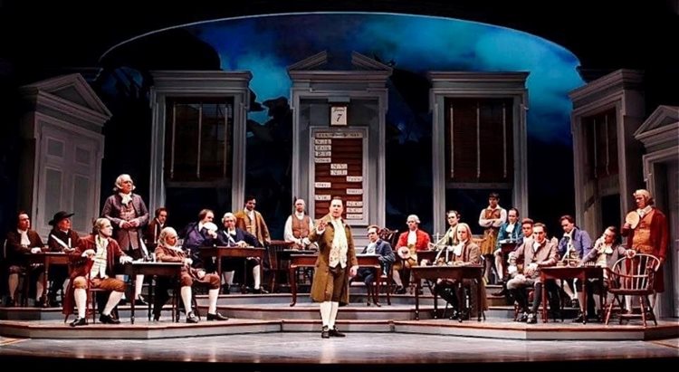 More than a dozen actors in full period costume grace the stage for a live performance at Ford’s Theatre in Washington, D.C.