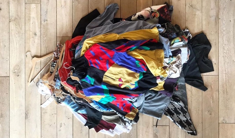 View from above of a colorful pile of clothes which are going to be donated before a move.