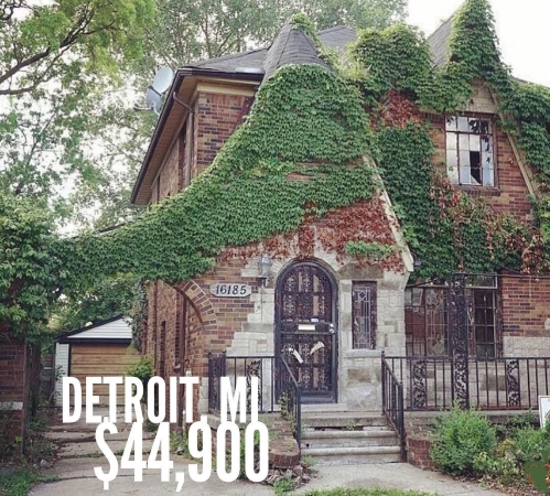 A low-priced historic mansion in Detroit, Michigan. The red brick home is covered in green vines and has several unique characteristics, including an arch over the driveway and a rounded front door.