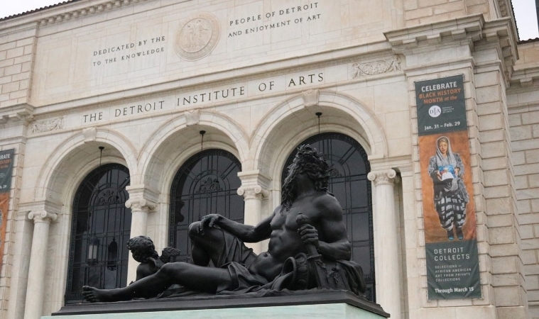 The entrance of The Detroit Institute of Arts, as seen from behind an impressive statue out front. 
