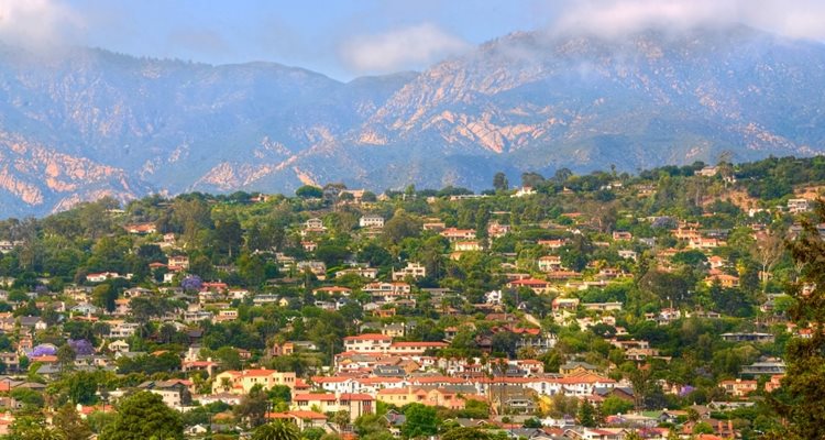 Distant view of the Riviera neighborhood in Santa Barbara, California. In the distance, mountains block a clear blue sky.