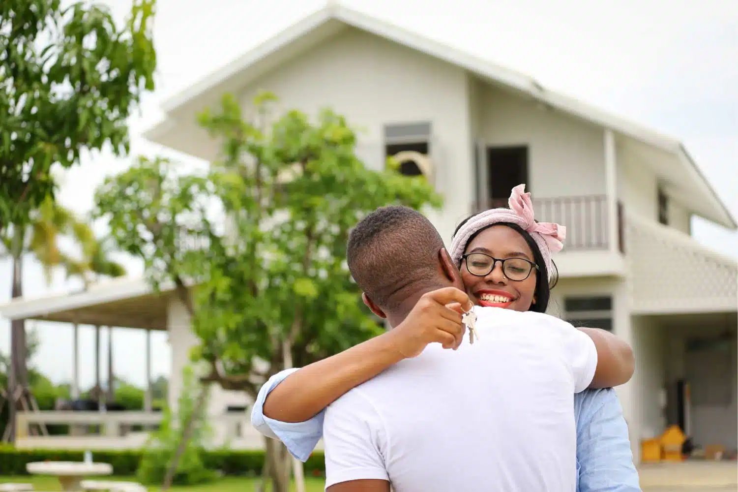 happy couple hugging outside new home