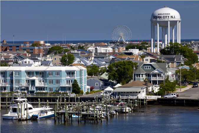 View of Ocean City, New Jersey, featuring a waterfront residential neighborhood, marina, city water tower, and Ferris wheel. 