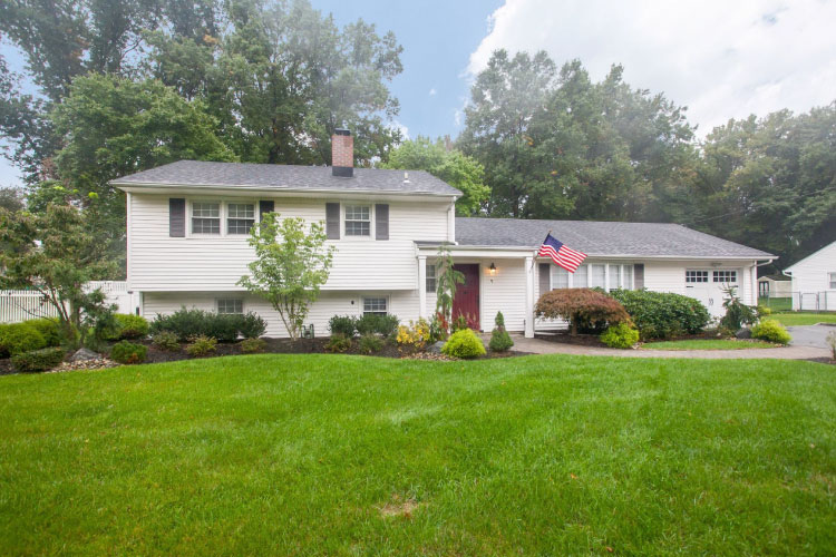 This split-level home in Edison, New Jersey, backs up to a densely wooded area and features a large front yard with professional landscaping.