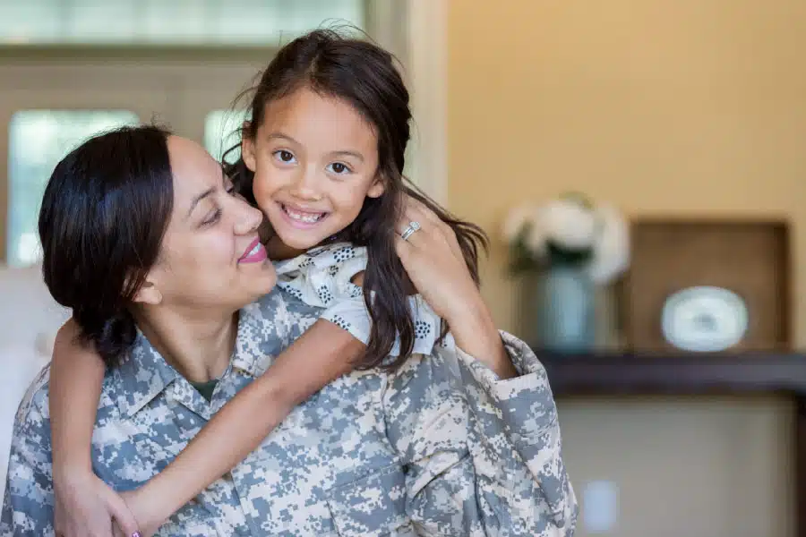 military woman holding her daughter