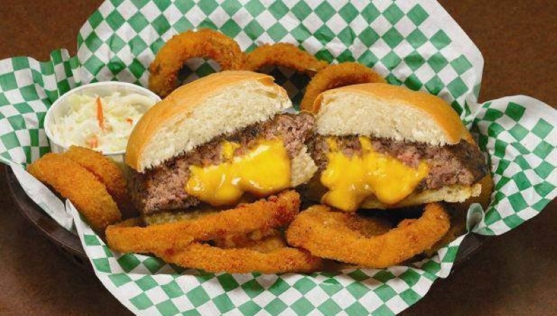 A paper-lined basket with onion rings and a cheese-filled hamburger — also known as the Jucy Lucy in Minneapolis.