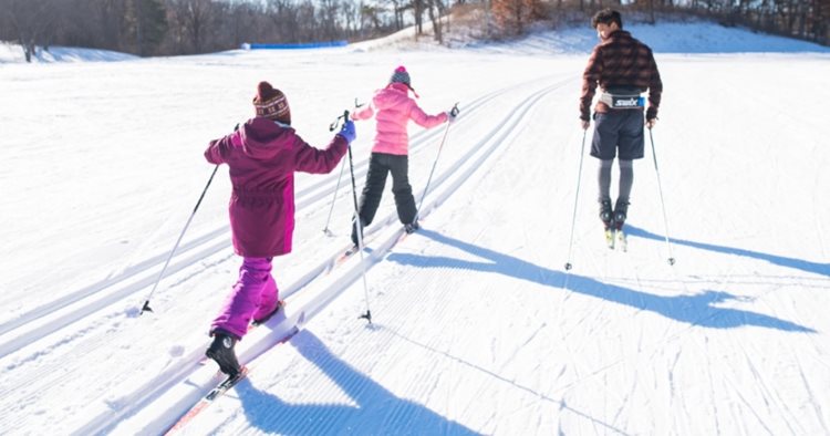 A father and his two young daughters enjoy some cross-country skiing in Minneapolis, Minnesota.