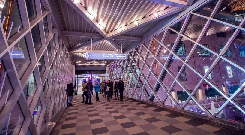 Friends congregate in one of the covered walkways of the Minneapolis Skyway on a cold winter day. 