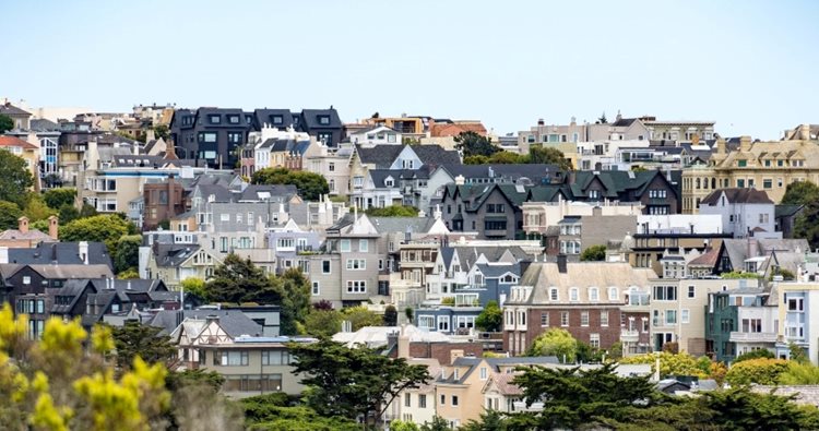 Distant view of an expensive neighborhood in San Francisco, California. The homes are large and luxurious, built on a slight elevation so they appear to become larger in the distance. 