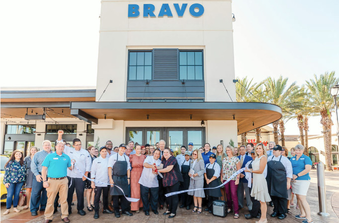 A group of people at a ribbon-cutting in front of a new business in Sarasota, Florida.