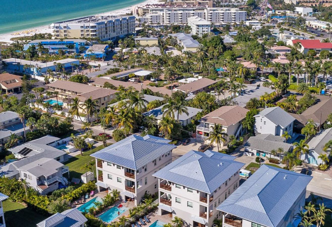 An aerial shot of a residential area of Siesta Key with the beach and Gulf of Mexico in the background.