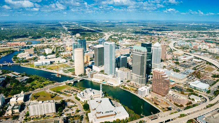 Aerial view of the Hillsborough River and downtown Tampa with freeways winding through the city.