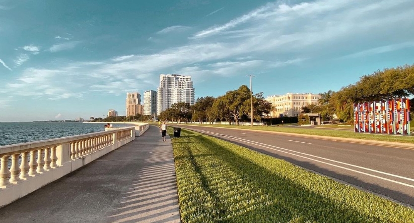 A couple of people are strolling along Bayshore Boulevard in Tampa, Florida, on a beautiful spring day. 