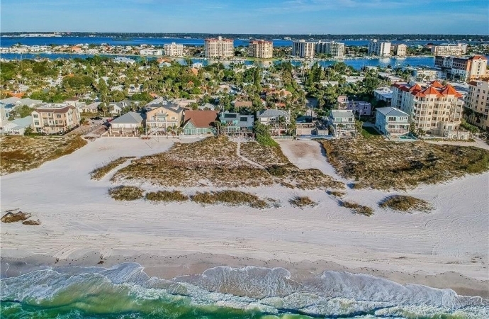 Aerial view of Clearwater Beach, Florida, from the Gulf of Mexico. Sugar-sand beaches and grassy sand dunes separate large hotels and beachfront homes from the warm waters of the Gulf. 