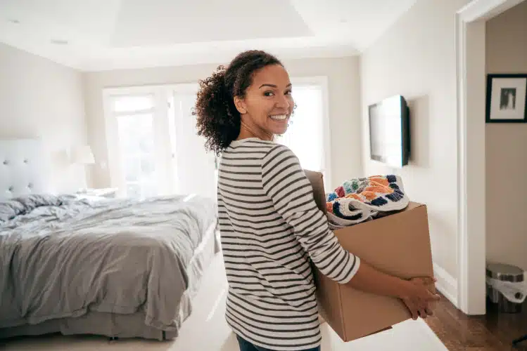 woman decluttering and carrying box