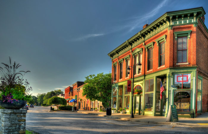 Red brick storefronts in the quaint downtown of Midway, Kentucky, on a clear summer day.