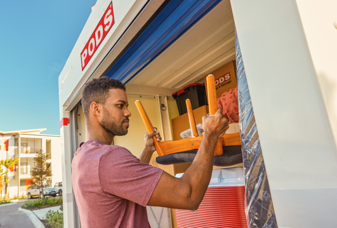 A man carefully loads his PODS portable moving and storage container. 