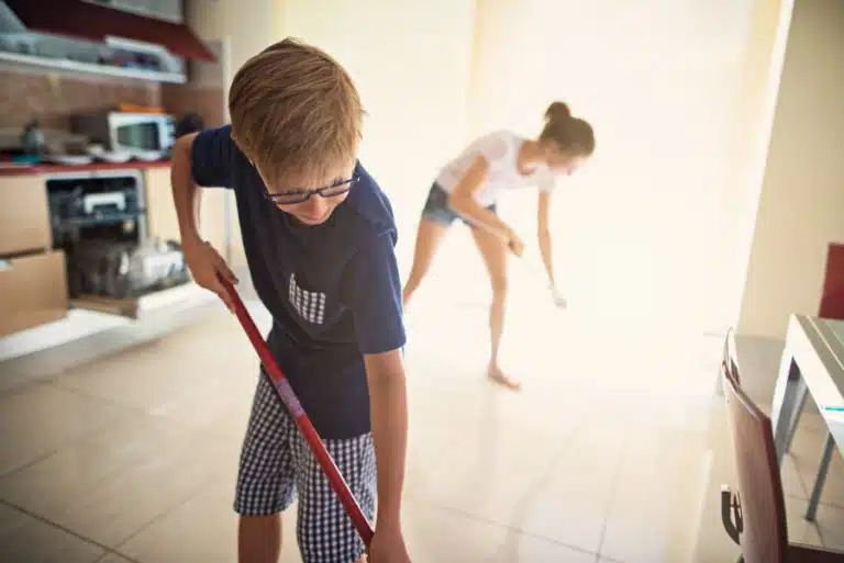 brother and sister cleaning the kitchen