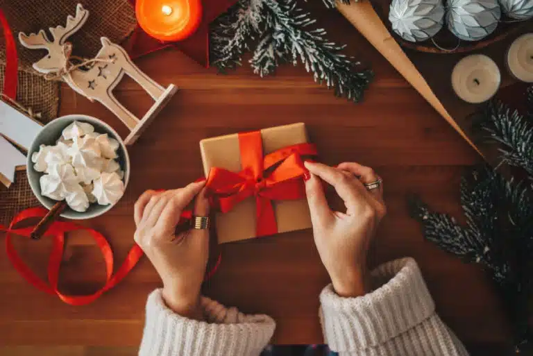 A woman wrapping a small gift for a white elephant exchange