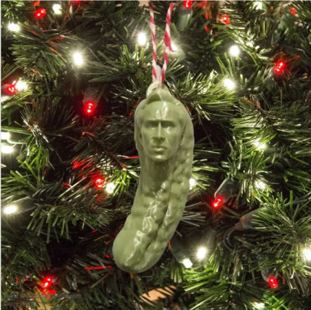 Close-up of a Christmas ornament hung on a tree that looks like Nicolas Cage as a pickle
