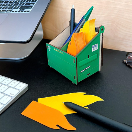 A cute and funny pen holder designed to look like a dumpster with little  fire-shaped post-it notes