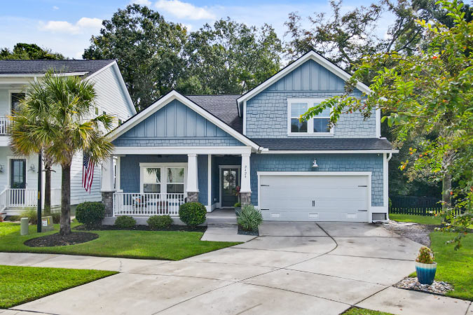 A beautiful split level home on Johns Island in Charleston, South Carolina, featuring a blue shingle exterior and a covered porch.