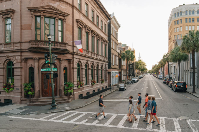 A group of tourists cross a street in Charleston, South Carolina, during a historic walking tour of the city.