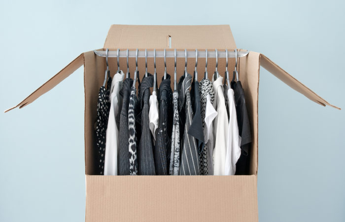An assembled wardrobe box is filled with 14 items of hanging clothing.