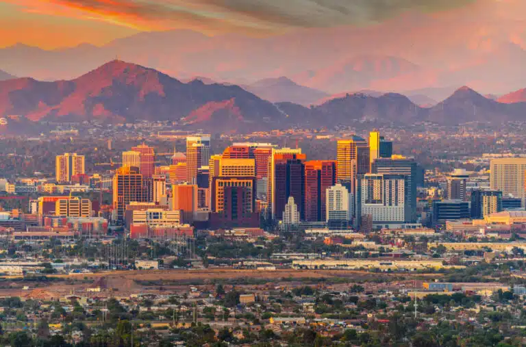 Distant sunset view of the Phoenix, Arizona, skyline and the range of mountains behind the city.