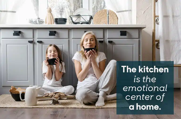 mother and daughter have cookies and coffee on the kitchen floor