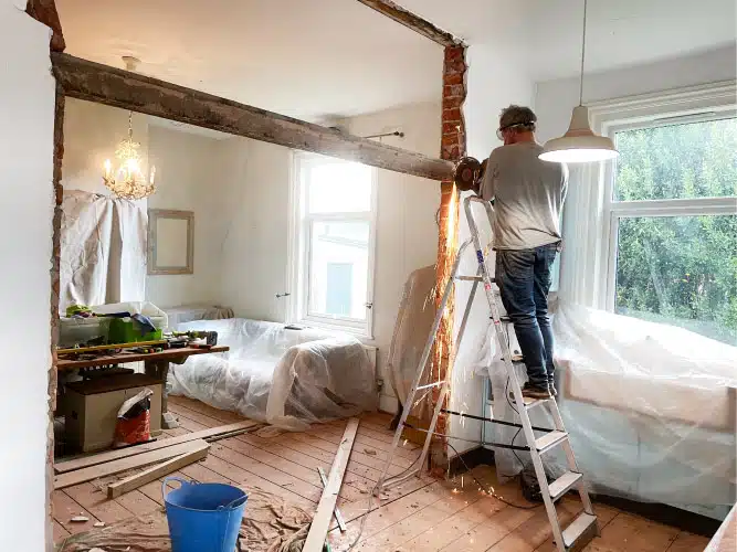 man tearing down a wall for home renovation