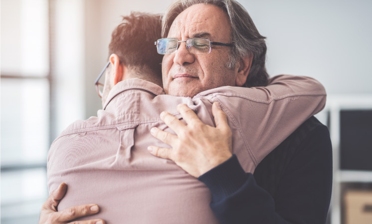 A father and son embrace as they prepare for the son to move out on his own.