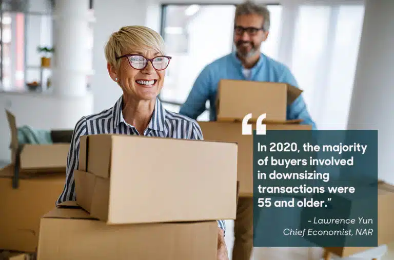 retired couple carrying moving boxes