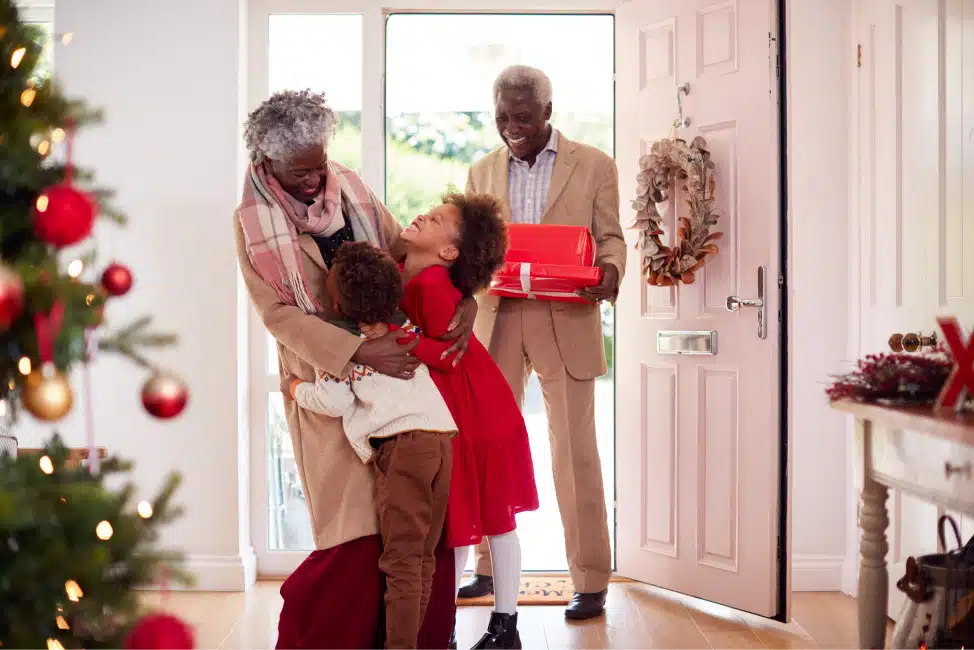 grandparents being welcomed by grandkids at Christmas