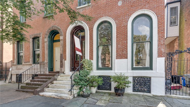 A brick condo building with ornate rounded windows and doorways in the Fairmount neighborhood of Philadelphia.